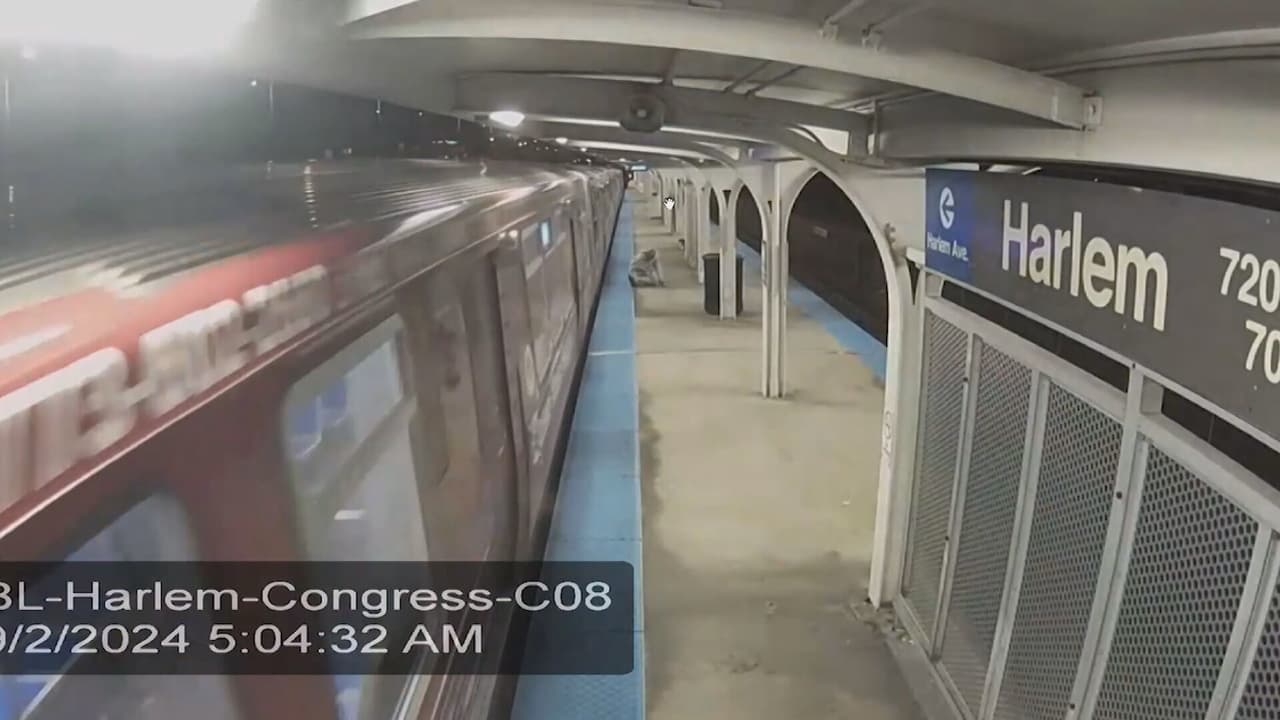 <b>5:04AM -</b> Se observa a un hombre vestido de gris brincar del vagón en movimiento en la estación Harlem.