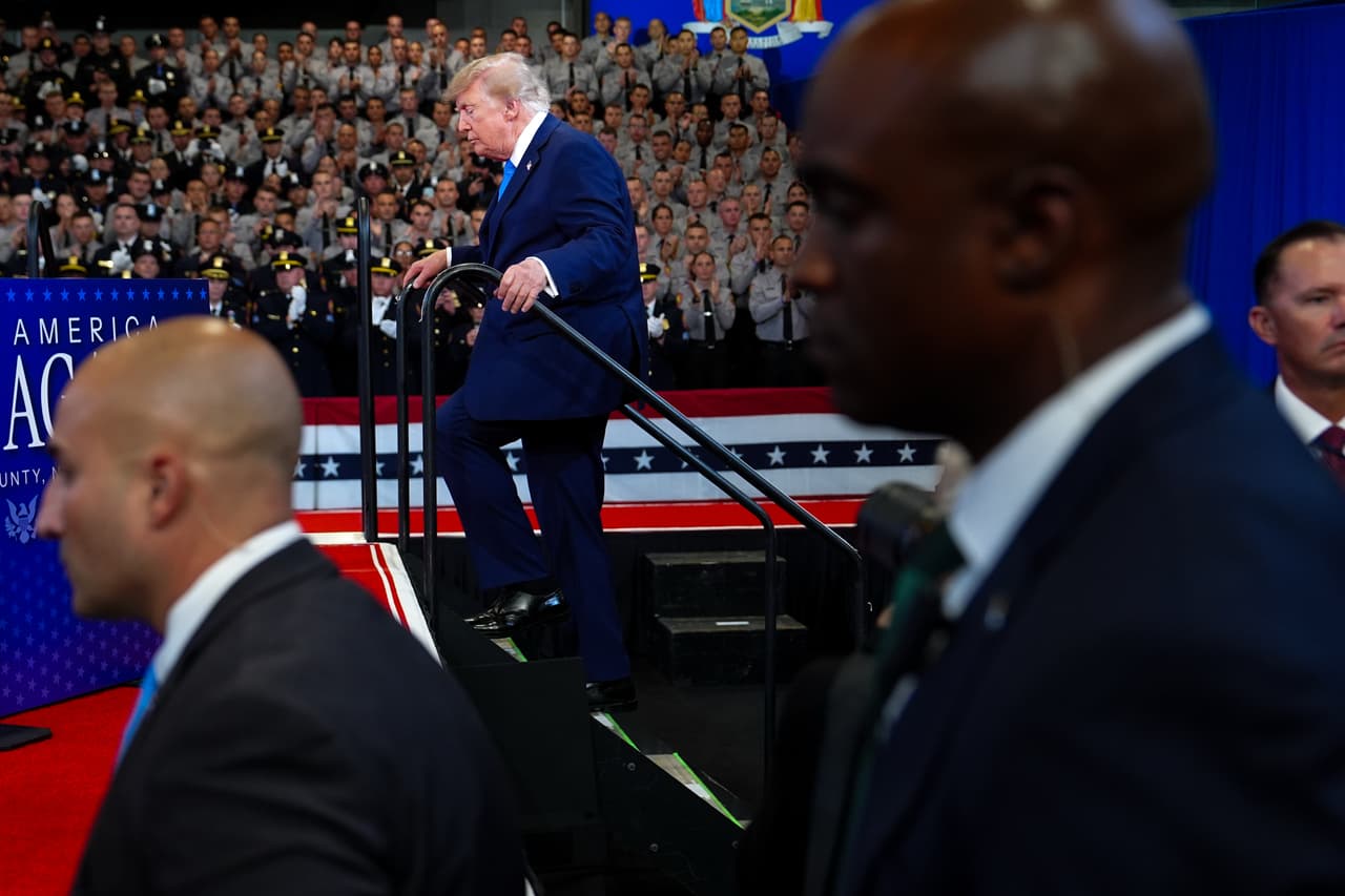 Agentes del Servicio Secreto de Estados Unidos vigilan mientras el presidente Donald Trump sube al escenario del Centro David Mack para Entrenamiento e Inteligencia, el viernes 14 de agosto de 2026, en Garden City, Nueva York.