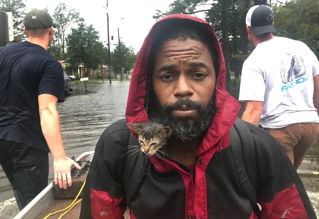 Robert Simmons Jr. and his kitten "Survivor" are rescued from floodwaters in New Bern, N.C., after Hurricane Florence dumped several inches of rain in the area overnight, Friday, Sept. 14, 2018. Hundreds were rescued from eastern North Carolina in the wake of the slow-moving storm. (Travis Long/Raleigh News & Observer/TNS via Getty Images)