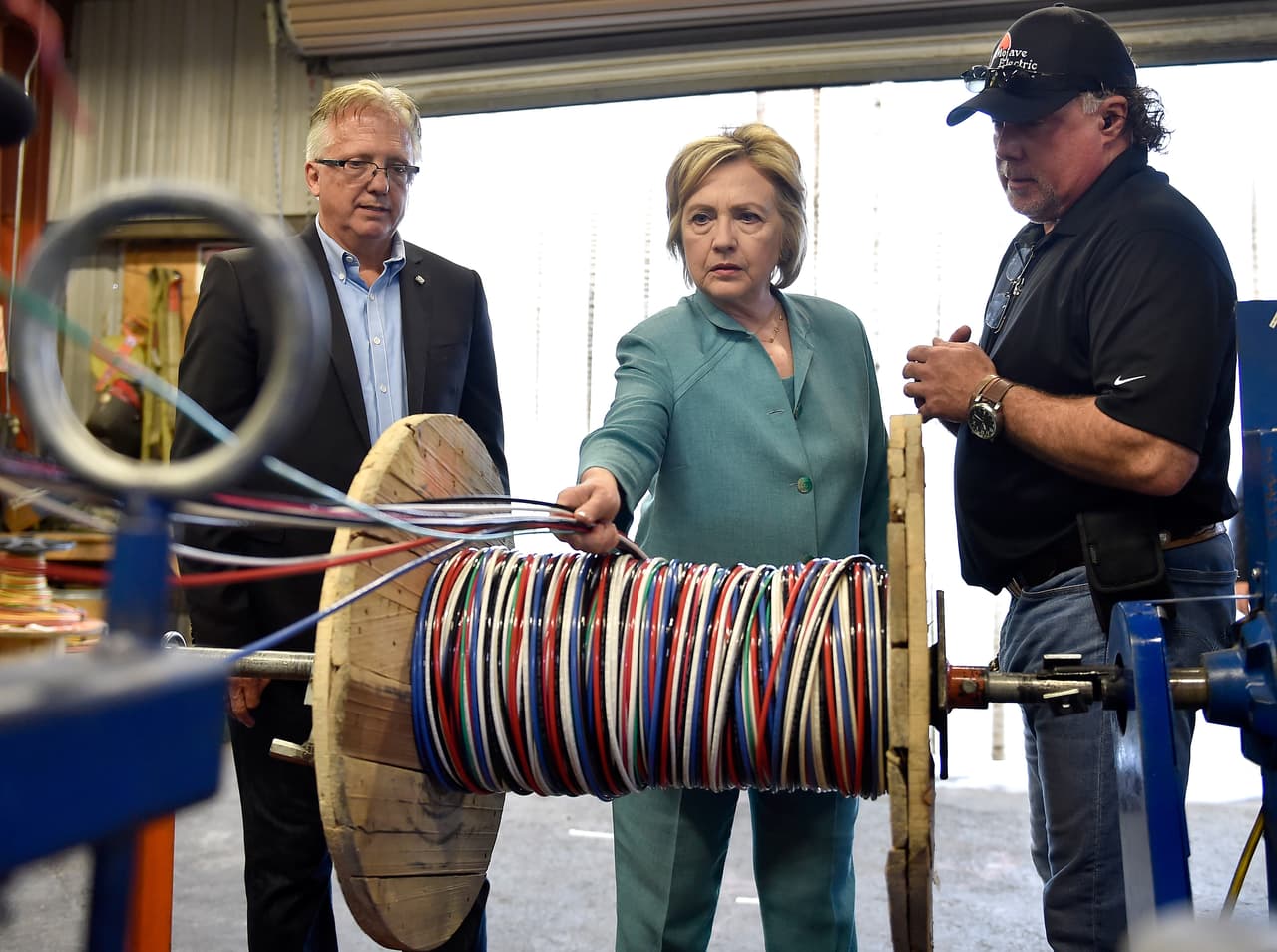 La candidata Hillary Clinton recorre la cooperativa local eléctrica Mojave en las Vegas junto al director ejecutivo de la Asociación Nacional de Contratistas Eléctricos capítulo Nevada, Donald Campbell (izquierda) y el Supervisor de Mojave Jackson Renner (derecha) el 4 de agosto de 2016.
