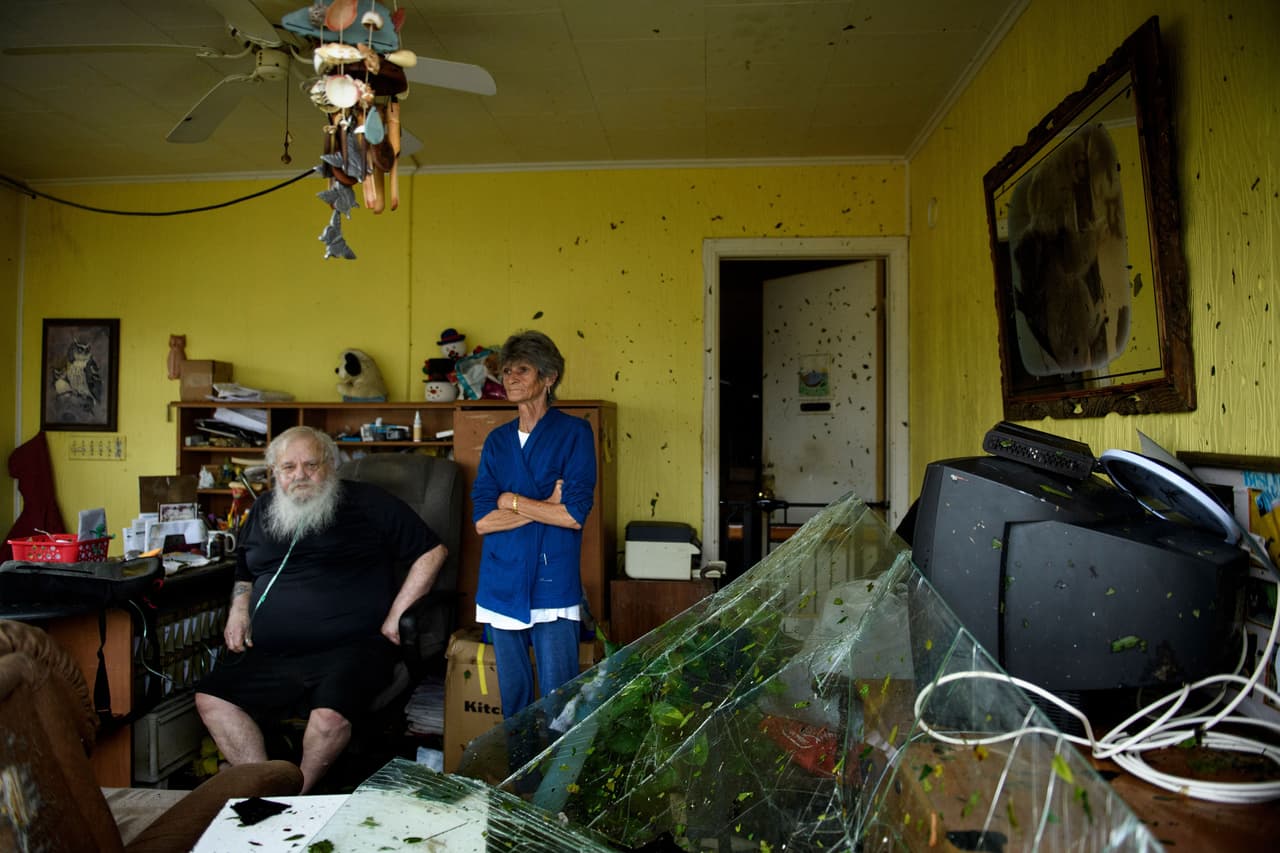 Charles Swaney, quien recibe oxígeno de una bombona, espera mientras otros examinan los daños causados por el huracán en Panama City.