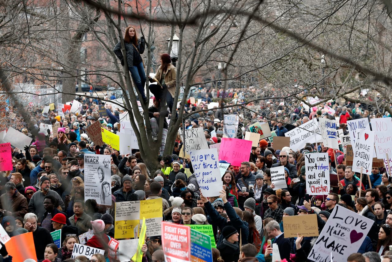 Dos mujeres encaramadas a un árbol observan la protesta de Washington.