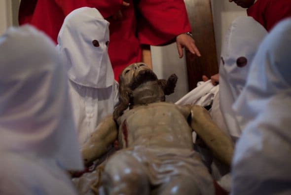 Los penitentes de Zamora bajan de la cruz la imagen de Jesucristo antes del inicio de su procesión.