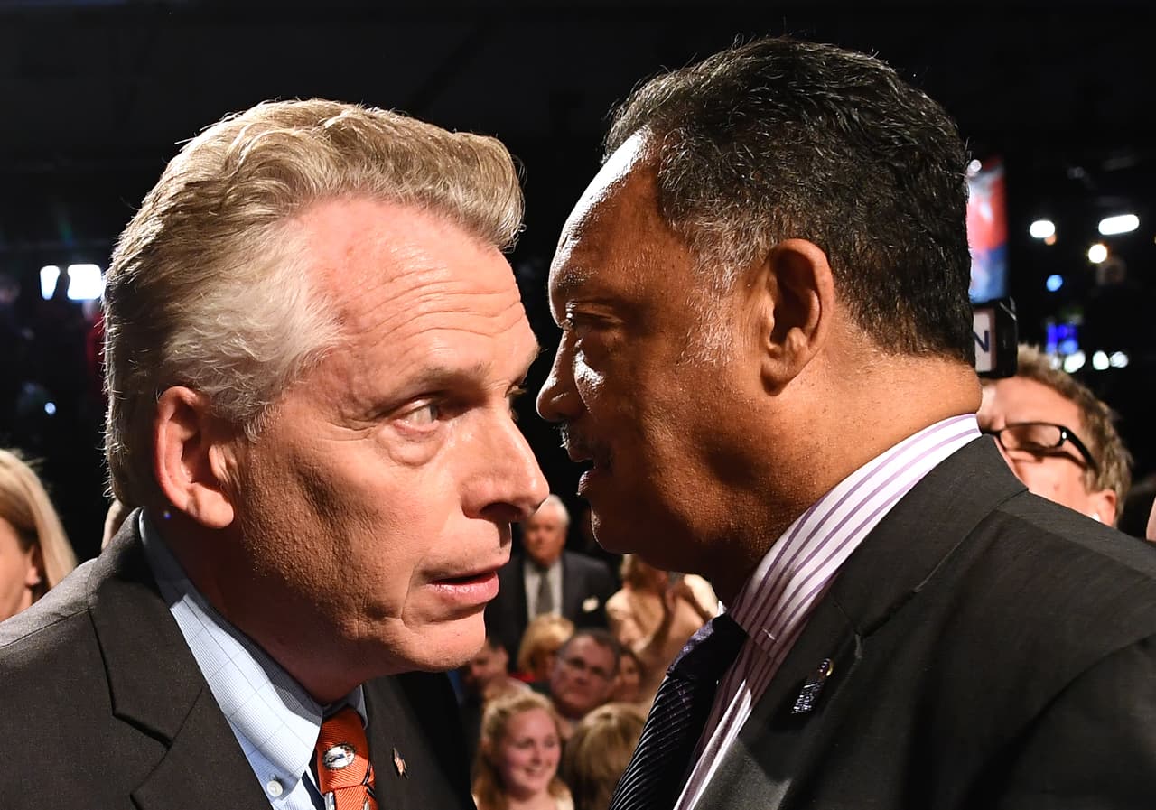 El reverendo Jesse Jackson saluda al gobernador de Virginia, Terry McAuliffe, antes de tomar asiento en el debate vicepresidencial.
