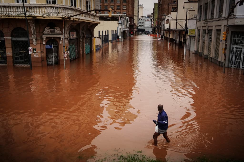 Un hombre camina por una calle inundada debido a las intensas lluvias, el viernes 3 de mayo de 2024, en Porto Alegre, estado de Río Grande do Sul, Brasil. (AP Foto/Carlos Macedo)