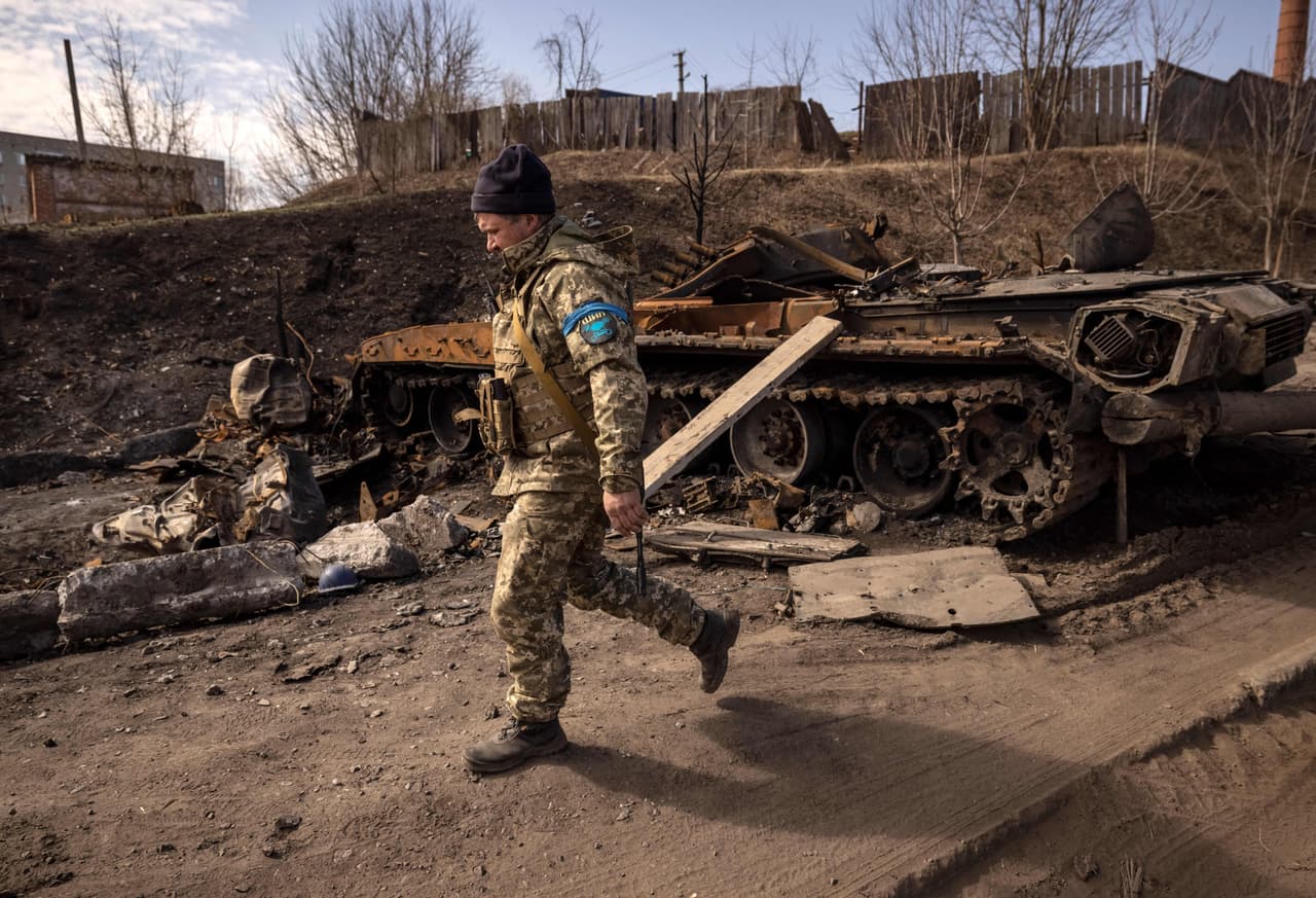 Un militar ucraniano camina cerca de un tanque del ejército ruso dañado en la ciudad nororiental de Trostyanets', el 29 de marzo de 2022. - Ucrania dijo el 26 de marzo de 2022 que sus fuerzas habían recuperado la ciudad de Trostianets, cerca de la frontera rusa, una de las primeras pueblos a caer bajo el control de Moscú en su invasión de un mes. (Foto de FADEL SENNA/AFP) (Foto de FADEL SENNA/AFP vía Getty Images)