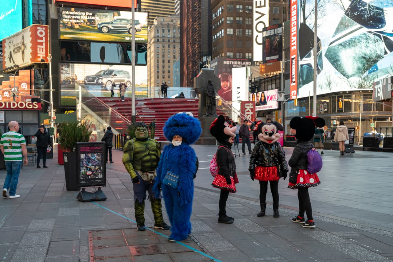 Los tradicionales personajes que entretienen a los turistas esperan en una vacía Times Square, en Manhattan. Estados Unidos implementó nuevas y drásticas restricciones para que la población salga a la calle y el presidenteTrump pidió a la población que no se reúnan en grupos de más de 10 personas.