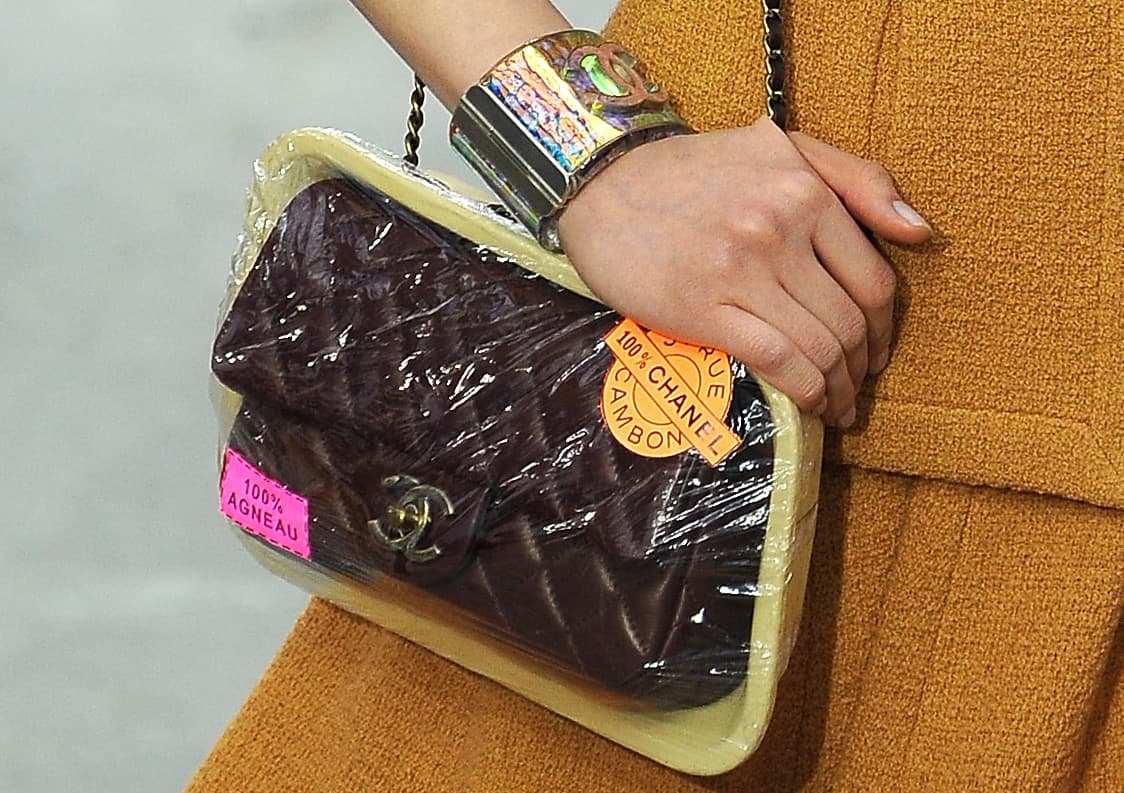 <b>¿Se puede sacar del envoltorio?</b>
<br>Sí, es un bolso envasado al vacío. Chanel decidió presentar su clásico bolso conocido como el "2.55" dentro de una bandeja cubierta de plástico, como las que venden en los supermercados. Fue en su desfile de Otoño/Invierno 2014 inspirado en los mercados. Quizás se lo tomaron demasiado literal.