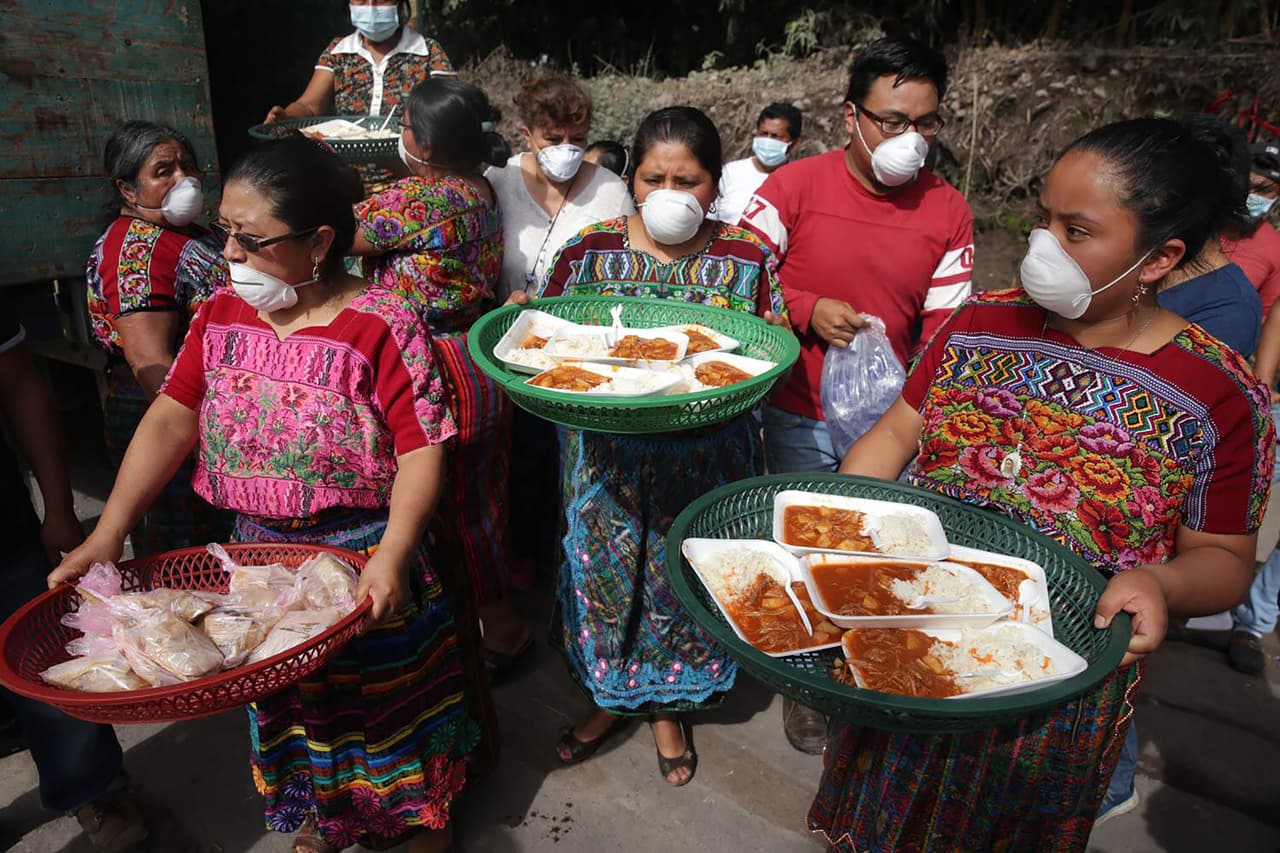 Mujeres de Santa Lucía Cotzumalguapa entregan comida para rescatistas en la falda del volcán de Fuego. El director del Instituto Nacional de Ciencias Forenses de Guatemala (Inacif), Fanuel García, dijo a Reuters que aún seguían recibiendo cuerpos, aunque cada vez con menos frecuencia.