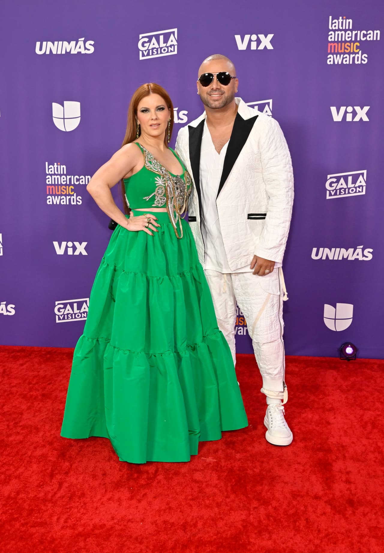 <b>Wisin y su esposa, Yomaira Ortiz Feliciano</b>
<br>
<br>La pareja vistió looks complementarios: mientras que el reggaetonero se enfundó en un traje blaco, Yomaira Ortiz Feliciano lució un vestido verde vibrante. 
<br>