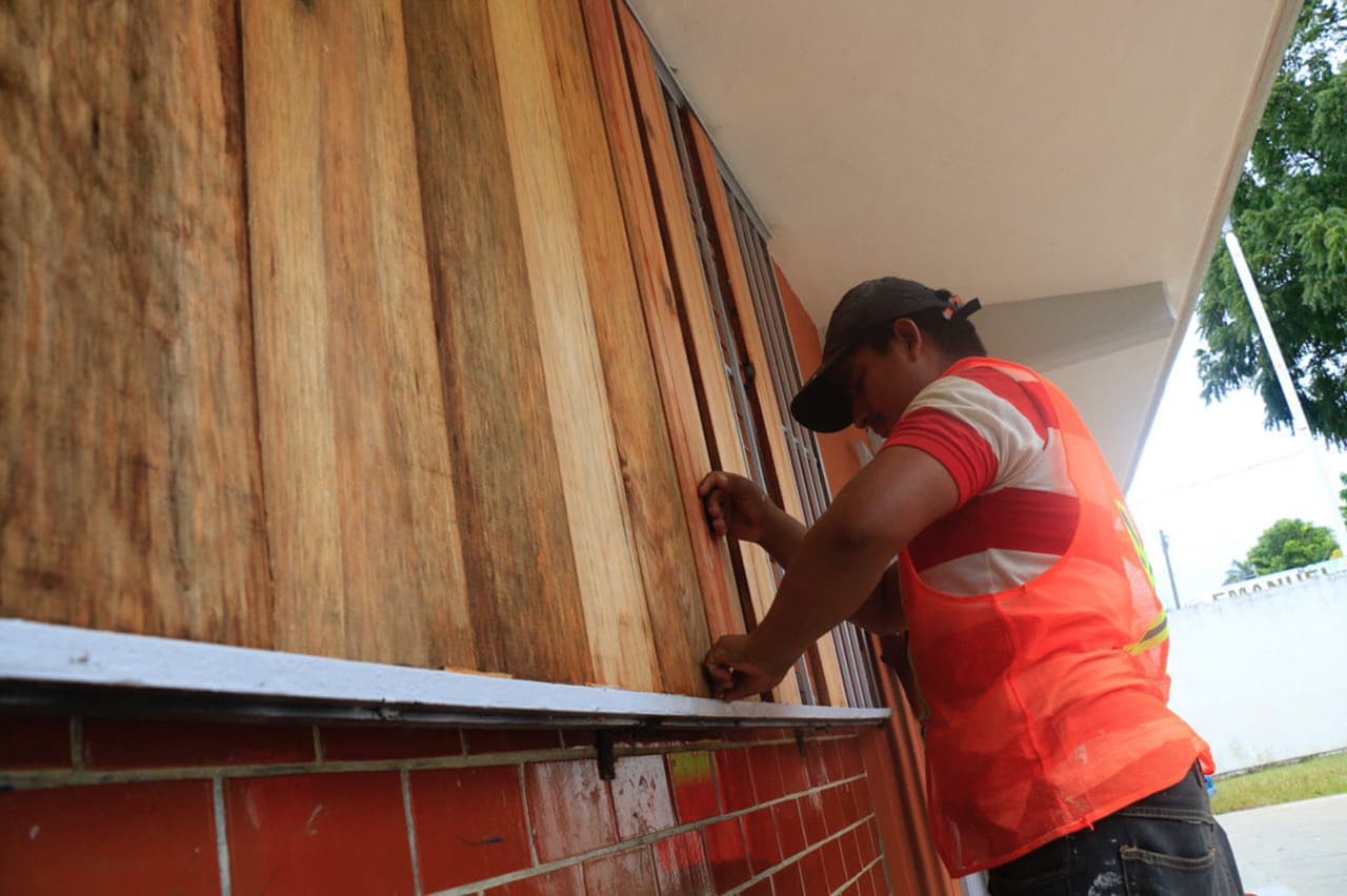 Un trabajador cubre las ventanas de un comercio en Chetumal, Quintana Roo, antes de la llegada del temporal.