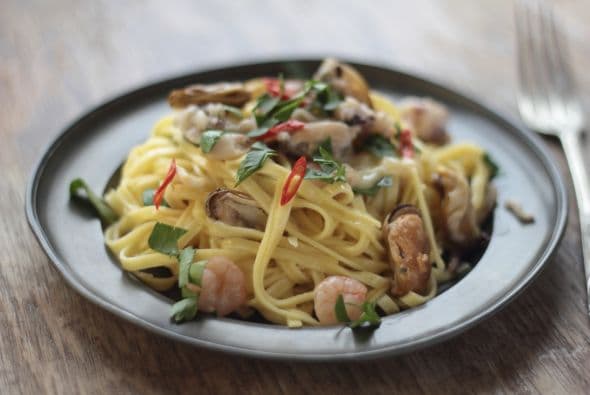 Revuelve todo y, para el toque final, añade 2 onzas (56 g) de queso Parmesano rallado, y los trocitos de tocino. Mezcla nuevamente.