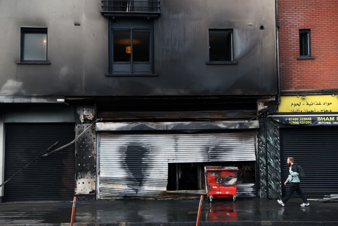 Vista de una tienda de comestibles con apartamentos calcinados tras los disturbios en el centro de Belfast. (Foto AP/Peter Morrison)