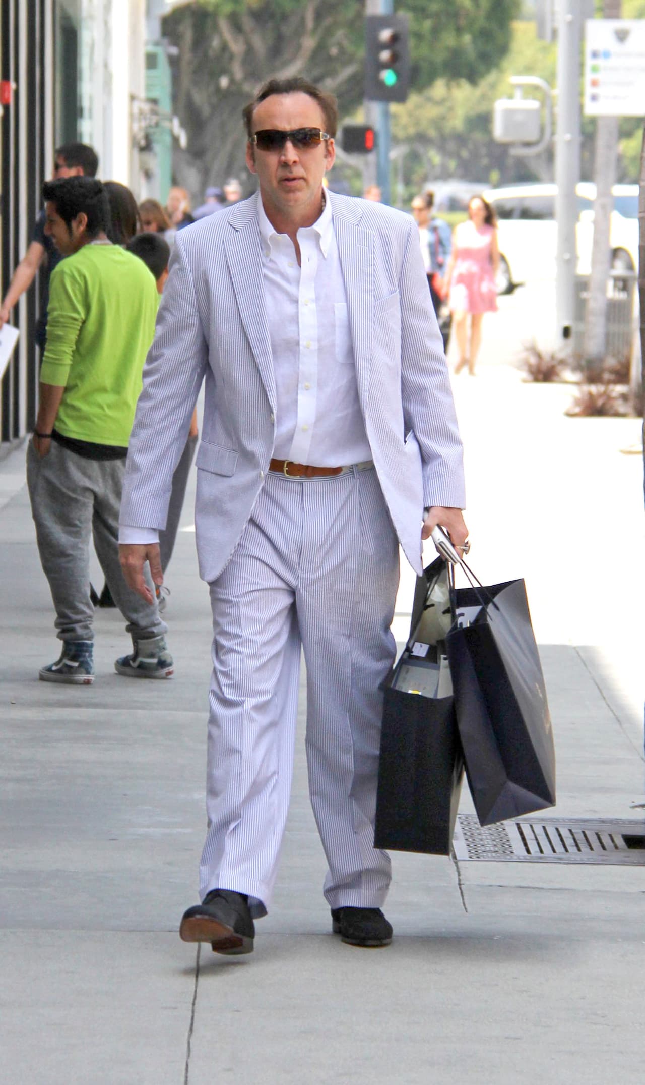 Nicolas sujetaba las bolsas de sus compras con una mano.