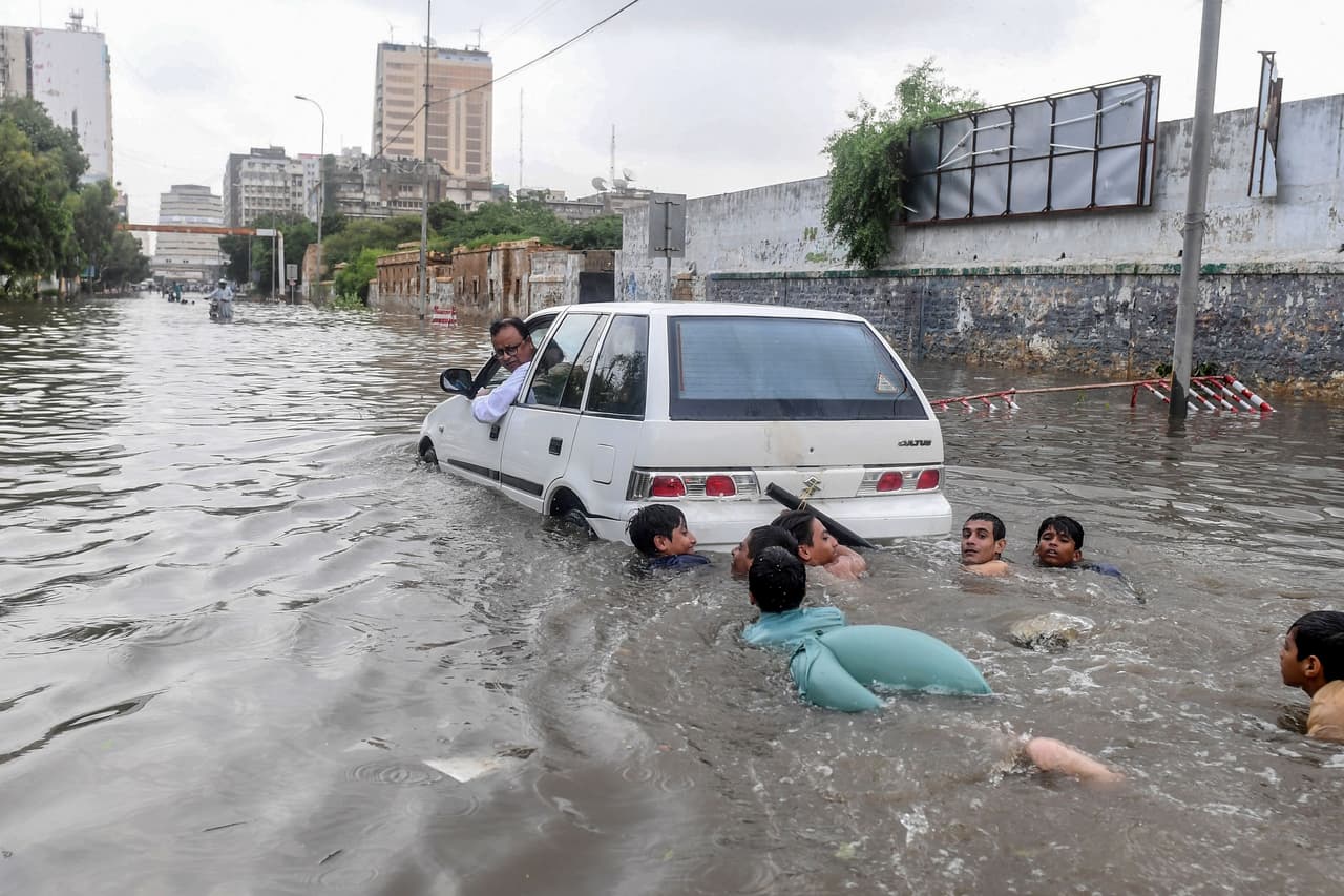 <b>Devastadores monzones en Pakistán. </b>Un grupo de jóvenes nada en una calle inundada en Karachi el 28 de agosto. Las fuertes lluvias monzónicas provocaron históricas inundaciones y decenas de personas perdieron la vida.