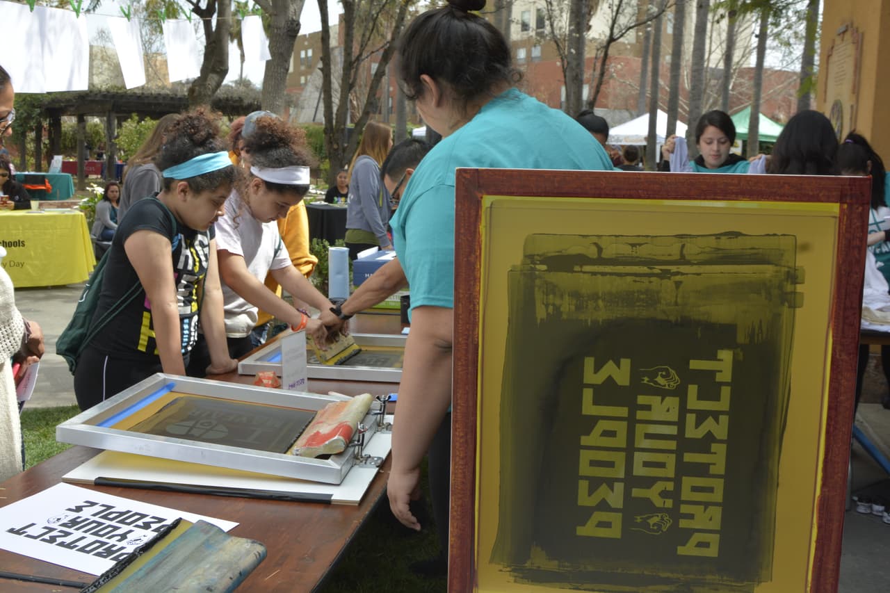 Niños aprendienden serigrafía durante un evento de Mayferia.