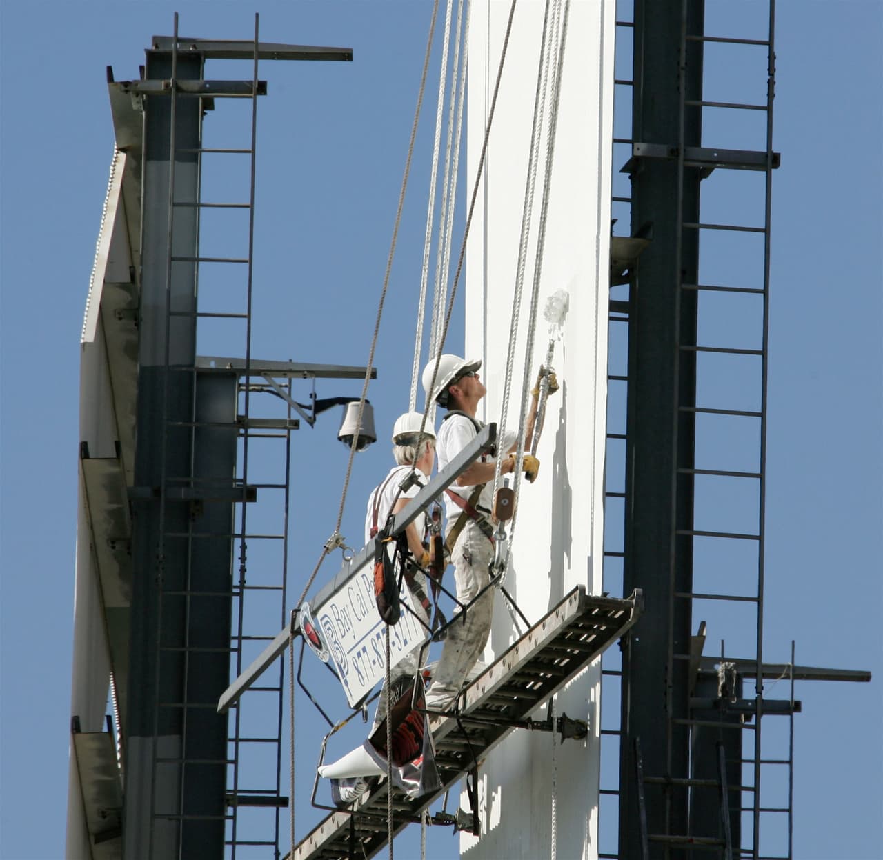 Unos pintores dan una capa de pintura blanca a una de las letras 'L' del letrero de Hollywood en noviembre de 2005. Volvió a ser pintado en 2012.