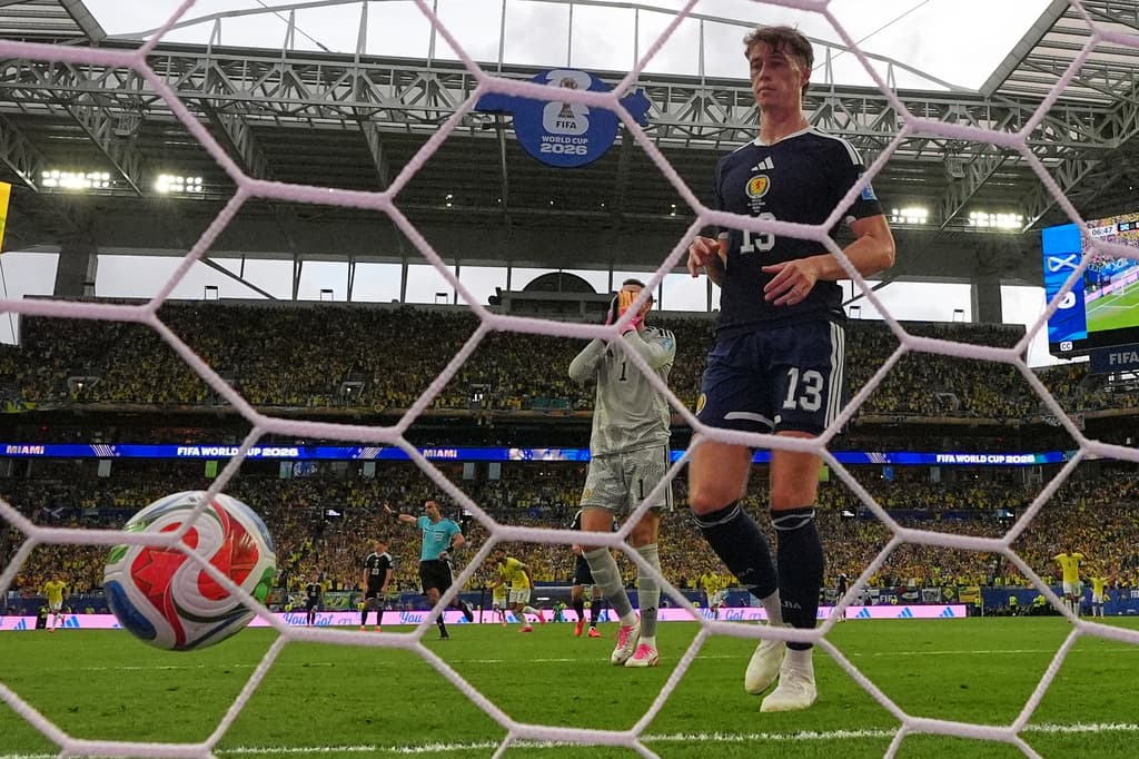 El portero de Escocia, Angus Gunn, y Jack Hendry reaccionan después de que el brasileño Vinicius Junior marcara un gol.