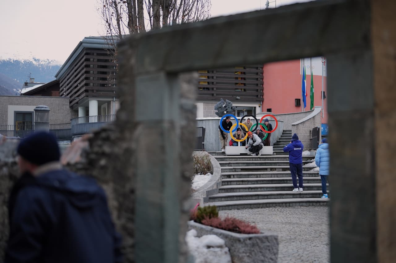 Personas posan para fotos junto a los anillos olímpicos en Bormio, Italia, durante los Juegos Olímpicos de Invierno de 2026, el martes 10 de febrero de 2026. (Foto AP/Rebecca Blackwell)