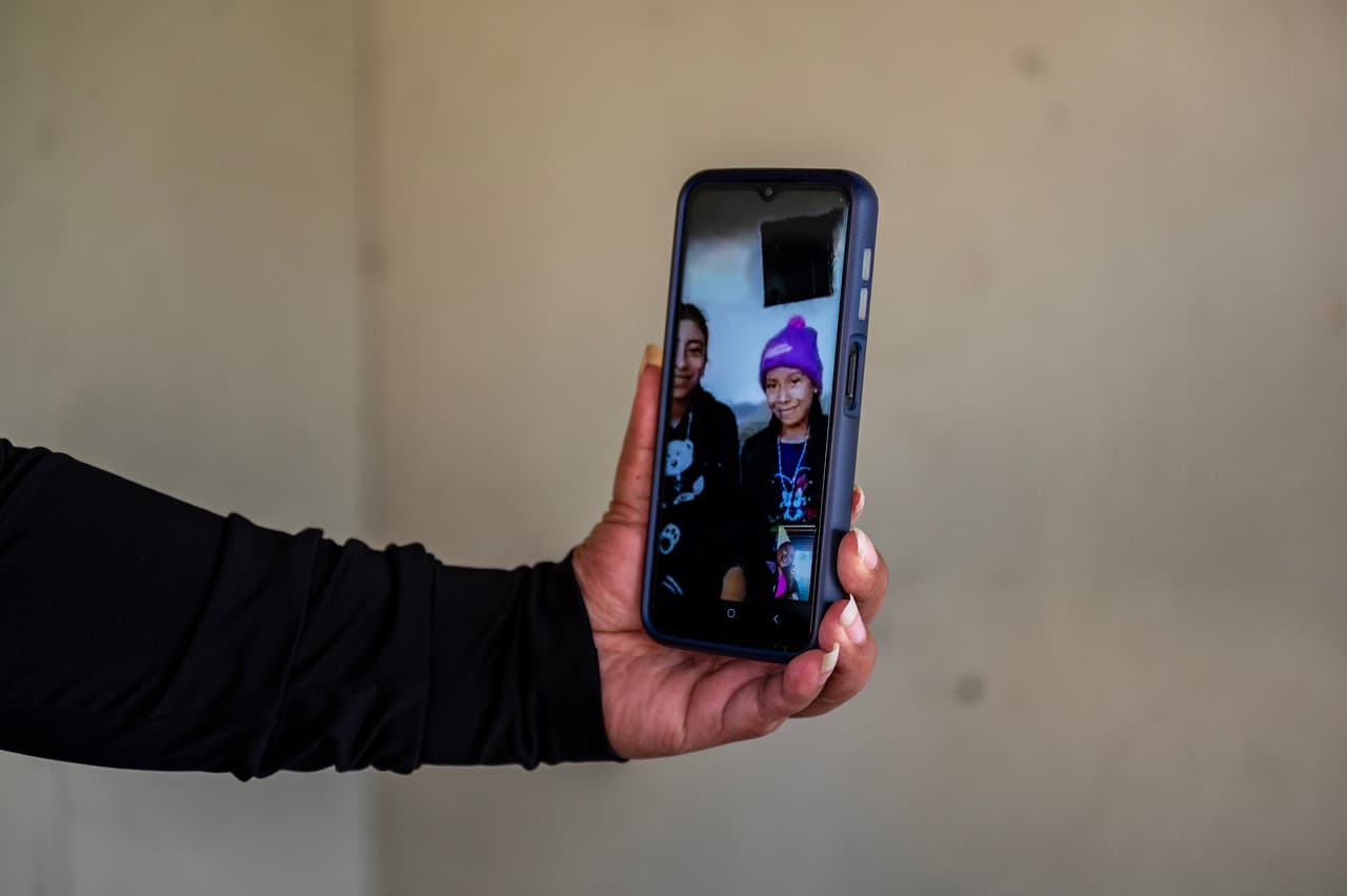 Rosmeri, de 12 años, y Dayana Ramírez Hernández, de 10 años, durante una videollamada por WhatsApp desde Guatemala el martes 18 de julio de 2023. Las hijas de Reyna compartían la pantalla y reían al hablar con su madre.