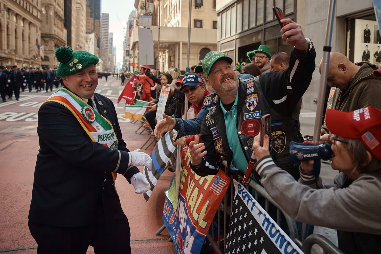 Un miembro del Departamento de Bomberos de Nueva York saluda a partidarios de Donald Trump durante el Desfile del Día de San Patricio.