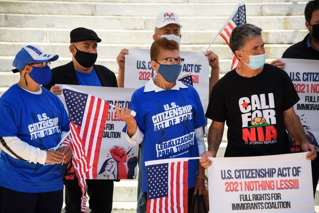 People hold signs and flags in support of the US Citizenship Act of 2021 and US President Biden's immigration reform plan outside of City Hall on April 29, 2021 in Los Angeles, California.