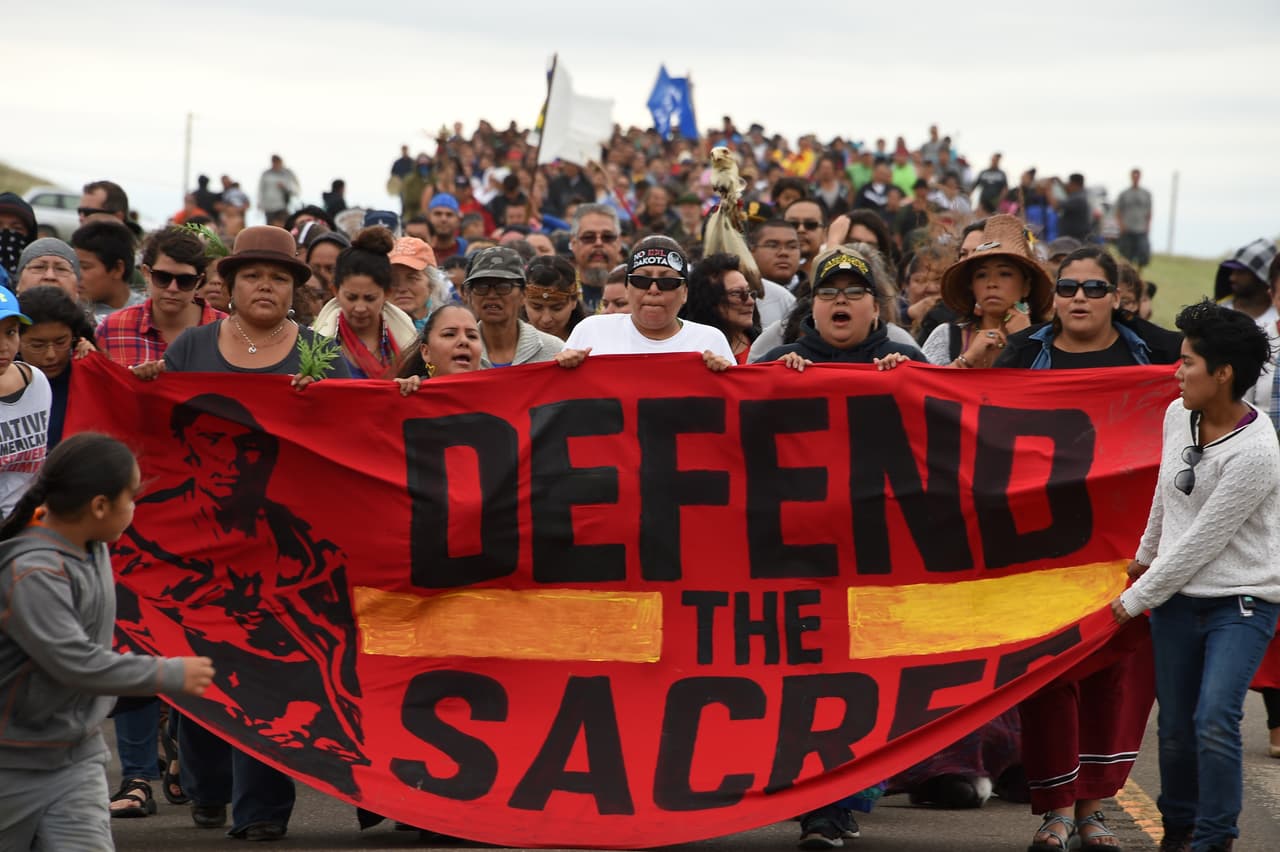 Un grupo de indios americanos marchan el 4 de septiembre, hacia un sitio sagrado de entierros que fue perturbado por topadoras que construyen el Oleoducto de Acceso Dakota (DAPL por sus siglas en inglés). La marcha transcurre adyacente a un campamento donde cientas de personas se reúnen en apoyo a la tribu Standing Rock Soiux en su protesta contra esta obra que, según los planes, cruzará el río Missouri en las cercanías.