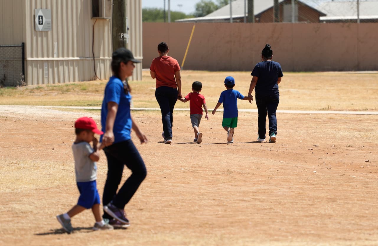 Los inmigrantes que buscan asilo se toman de la mano mientras cruzan el Centro Residencial Familiar ICE South Texas, el viernes 23 de agosto de 2019 en Dilley, Texas. El Servicio de Inmigración y Control de Aduanas de EEUU organizó un recorrido por los medios del centro que alberga a las familias que están pendientes de la disposición de sus casos de inmigración.