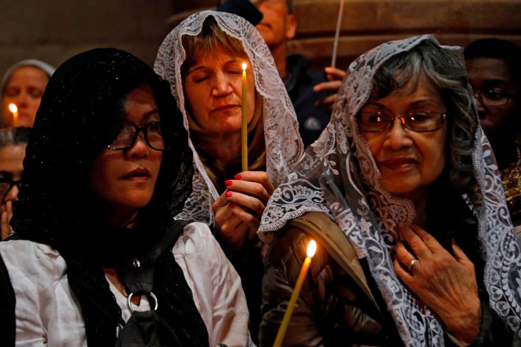 Un grupo de religiosas prende sus velas y sigue la procesión de Pascua en la Iglesia del Santo Sepulcro en Jerusalén.