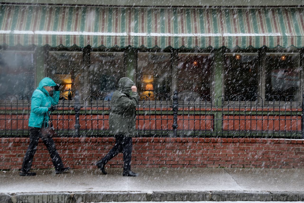 Los peatones se abren camino por el clima invernal en Mount Holly, Nueva Jersey. La mezcla de lluvia, aguanieve y nieve comenzó a caer a última hora de la mañana del jueves al sur de ese estado.