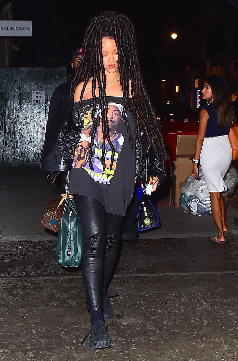 A juego con un pantalón ajustado en piel, zapatos tenis, todo en negro.