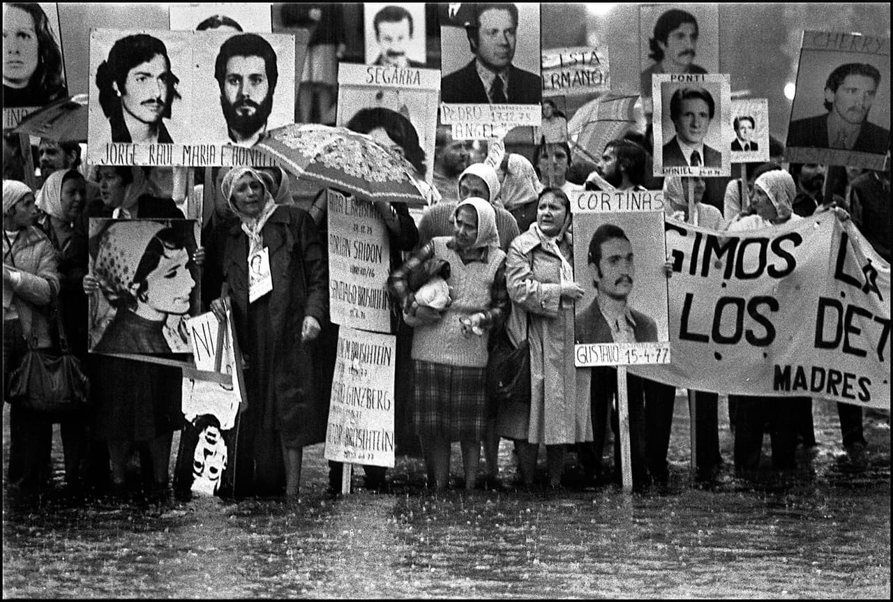 Nora Cortinas (C), president of the Madres de Plaza de Mayo Linea Fundadora human rights organization, holds a portrait of her missing son Gustavo during a mothers' demonstration in front of the government house in Buenos Aires circa 1982, during the military dictatorship (1976-83). Cortinas believes that the solving of the missing citizens problem is still pending and that the armed forces, the church and the politicians are still in debt with the society after 23 years of democracy. AFP PHOTO Daniel GARCIA / AFP / DANIEL GARCIA AND - (Photo credit should read DANIEL GARCIA/AFP/Getty Images)