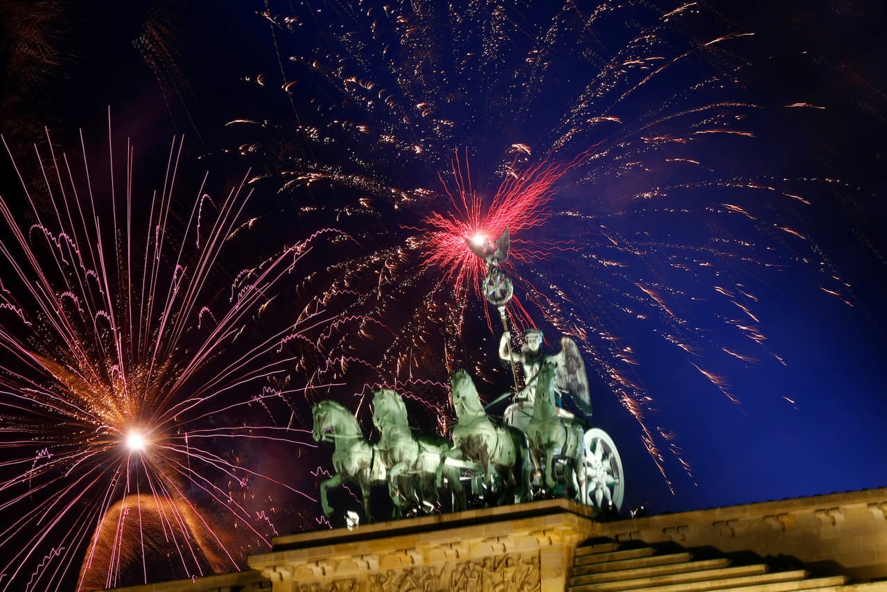 Fuegos artificiales en el cielo de Berlín. En primer plano la escultura de la cuadriga romana sobre la Puerta de Brandenburgo.