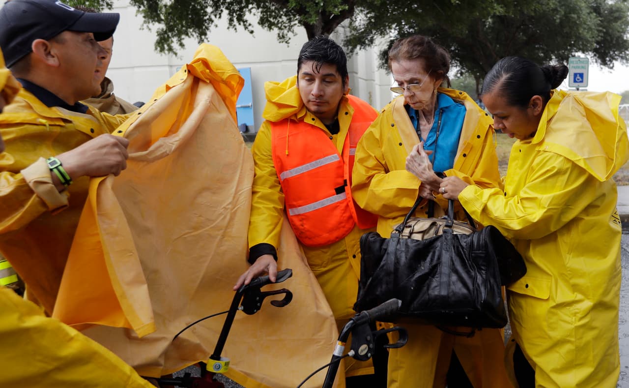 Martha Wilson, residente de Corpus Christi, es asistida por funcionarios de la ciudad para tomar el autobús en el que será evacuada.