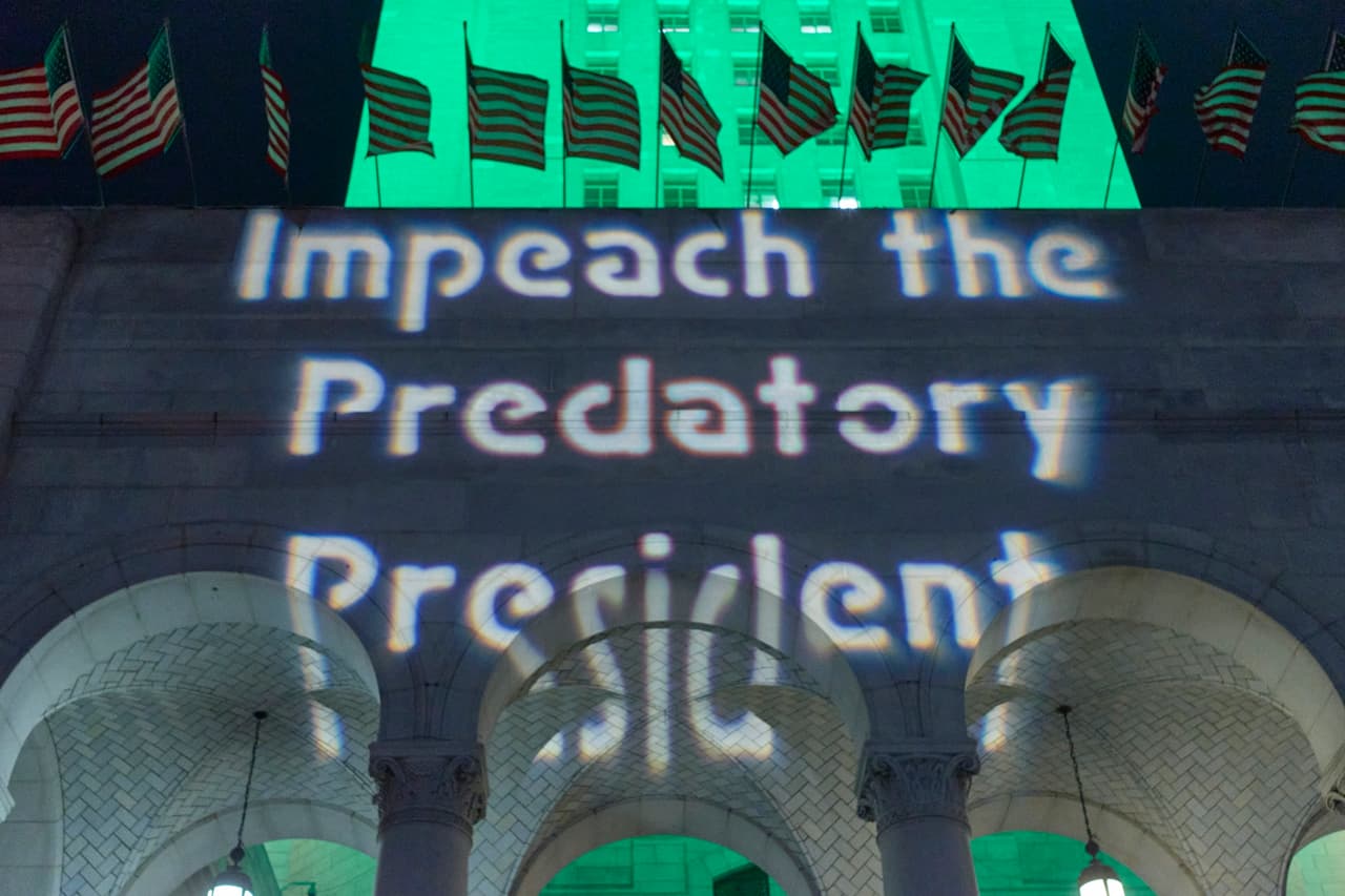 "Juicio al presidente depredador " se leyó en un anuncio proyectado en las paredes del ayuntamiento de Los Ángeles, el martes 17 de diciembre.