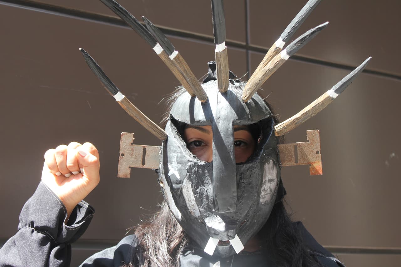 Melisa Álvarez colgó en su rostro el mensaje que buscó transmitir en el desfile: una máscara folclórica de Puerto Rico con la bandera en negro a un lado y el independentista boricua Óscar López Rivera al otro. “Estamos en una lucha, queremos a PR, tenemos los colores en nuestro corazón, pero estamos tristes", dijo la mujer de 31 años. (Patricia Vélez/Univision Noticias)