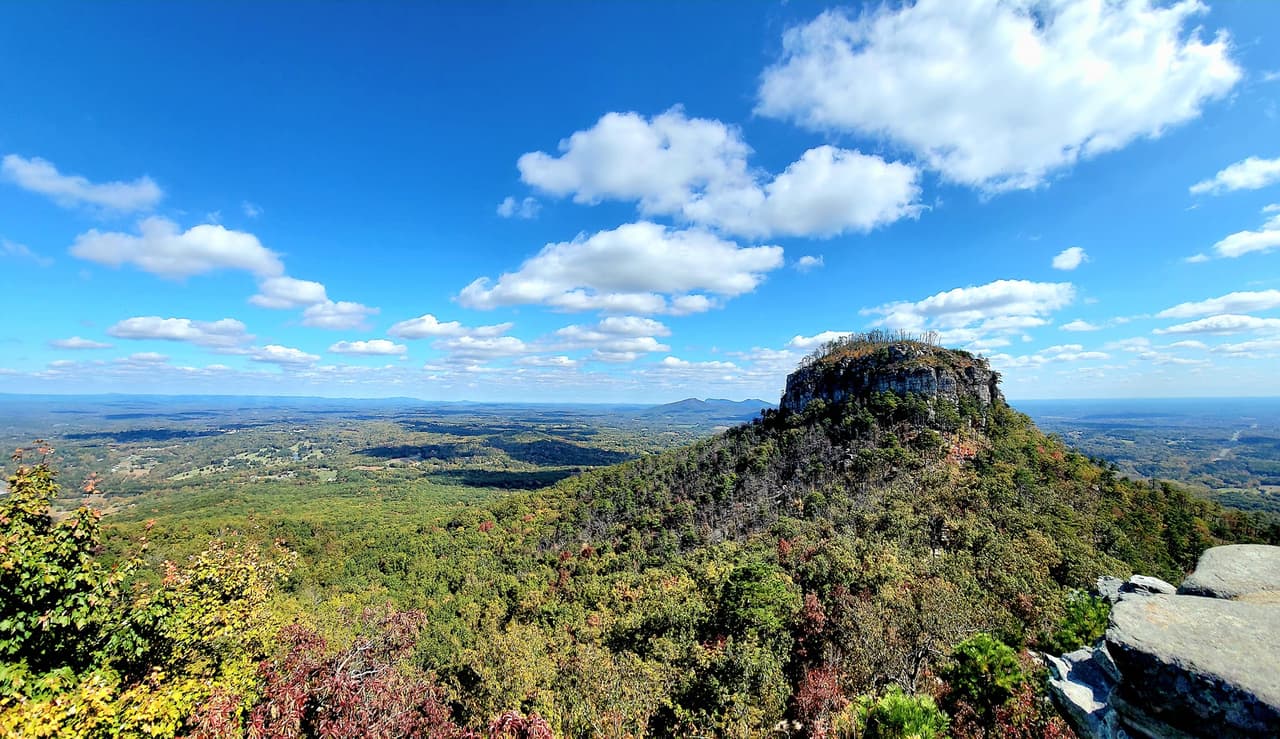 Conocido por su icónico pico redondeado que llega a los 2,000 pies, el
<b><a href="https://www.ncparks.gov/state-parks/pilot-mountain-state-park">Parque Estatal Pilot Mountain</a></b> ofrece millas de senderos para disfrutar de hermosas vistas, especialmente en la temporada de otoño.
