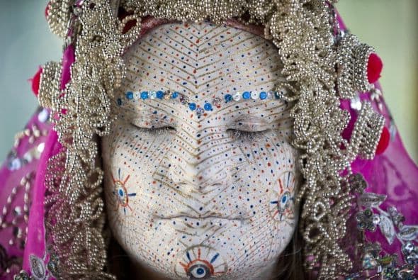 Una mujer de Bosnia posa luego de que su cara fue pintada para una ceremonia tradicional de bodas.