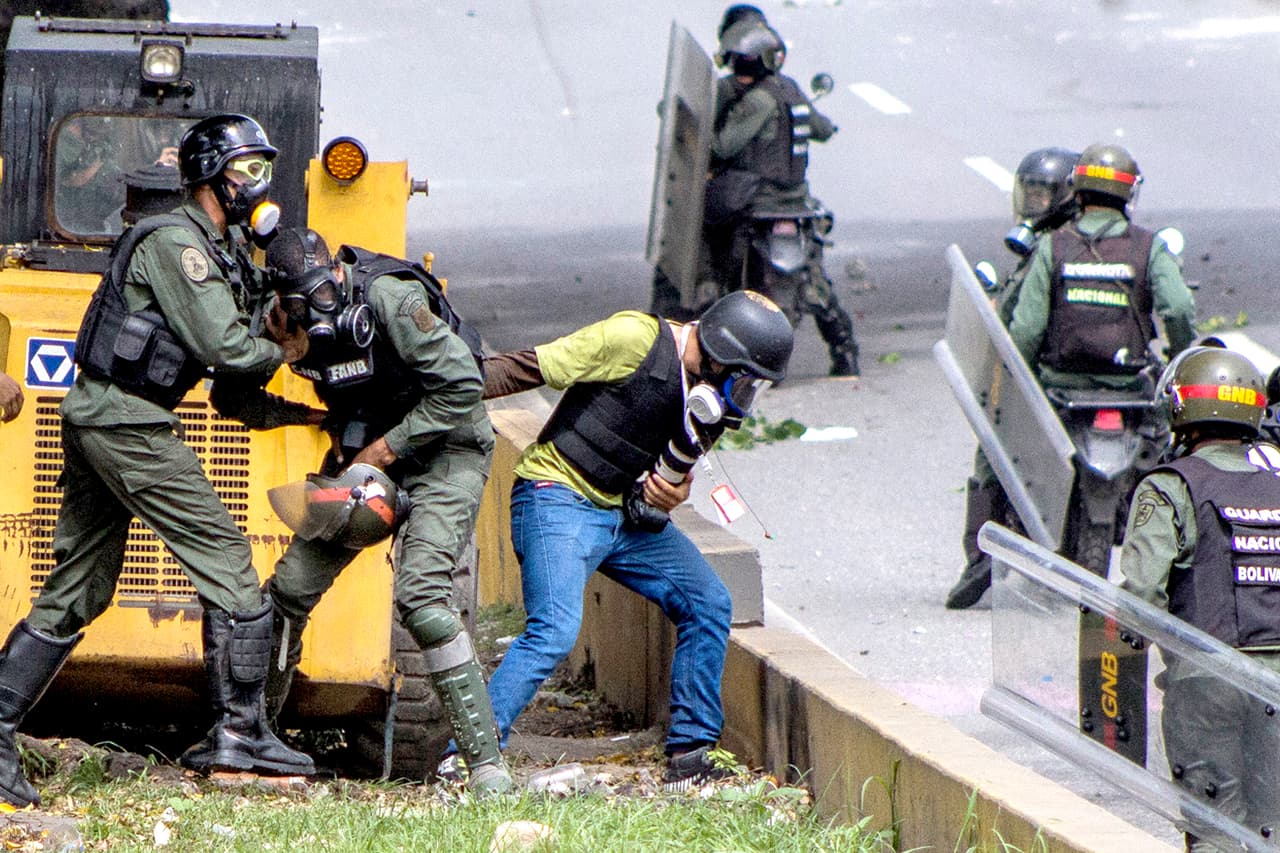 Funcionarios de la Guardia Nacional roban al fotoperiodista Francisco Bruzco en una protesta en Caracas el 31 de mayo de 2017. La Fiscalía venezolana había pedido el 18 de mayo medidas especiales para proteger a los reporteros que cubren las protestas contra el presidente Nicolás Maduro.