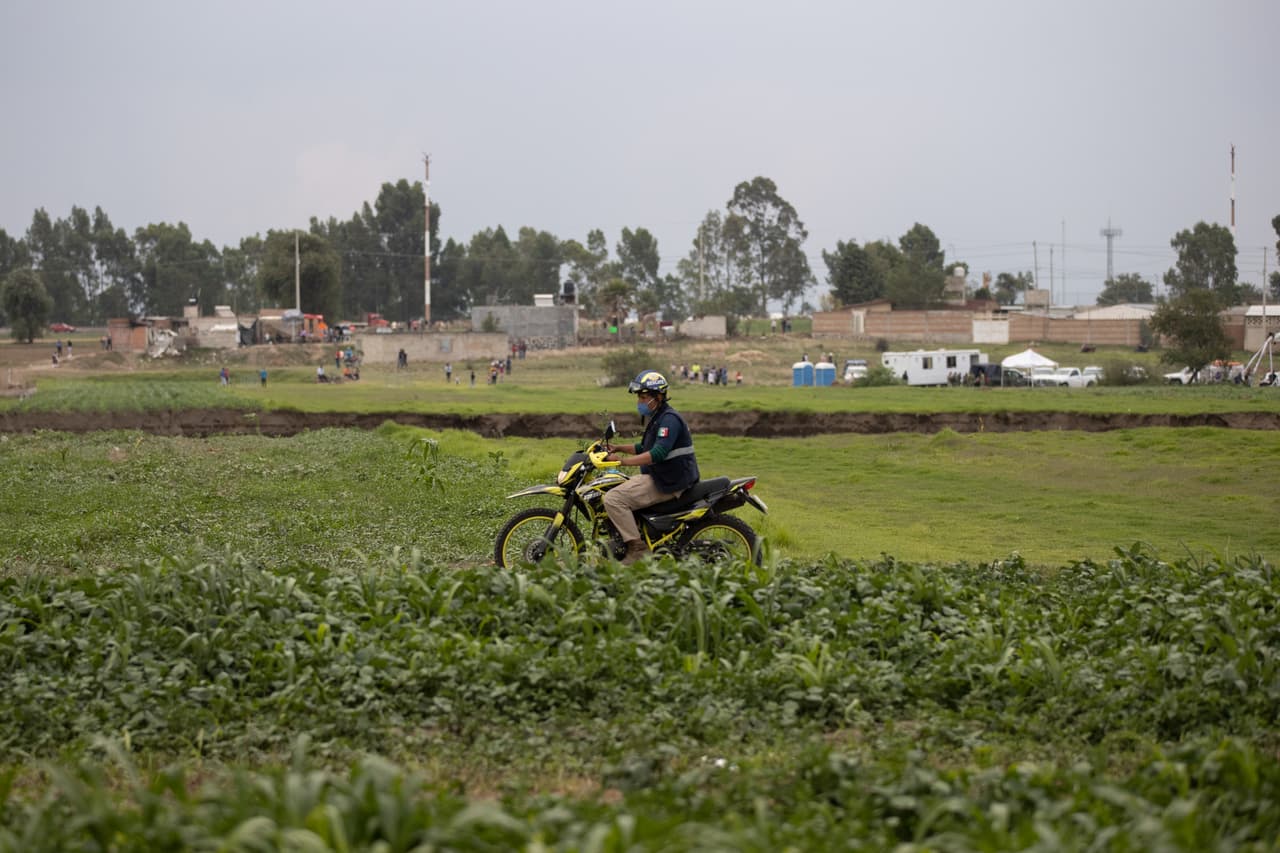 Un policía recorre el área cercana al socavón en Santa María Zacatepec, Puebla, al centro de México.
<a href="https://www.univision.com/noticias/edicion-digital/como-se-forma-un-socavon-como-el-que-se-abrio-esta-semana-en-mexico-albert-martinez-explica-video">El hoyo</a> está localizado a menos de 10 millas (20 kilómetros) al noroeste de la ciudad de Puebla y mide 400 pies de diámetro (125 metros).