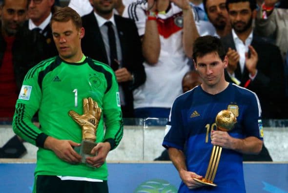 Manuel Neuer de Alemania sostiene el trofeo del Guante de Oro; Lionel Messi, de Argentina, sostiene el trofeo del Balón de Oro.