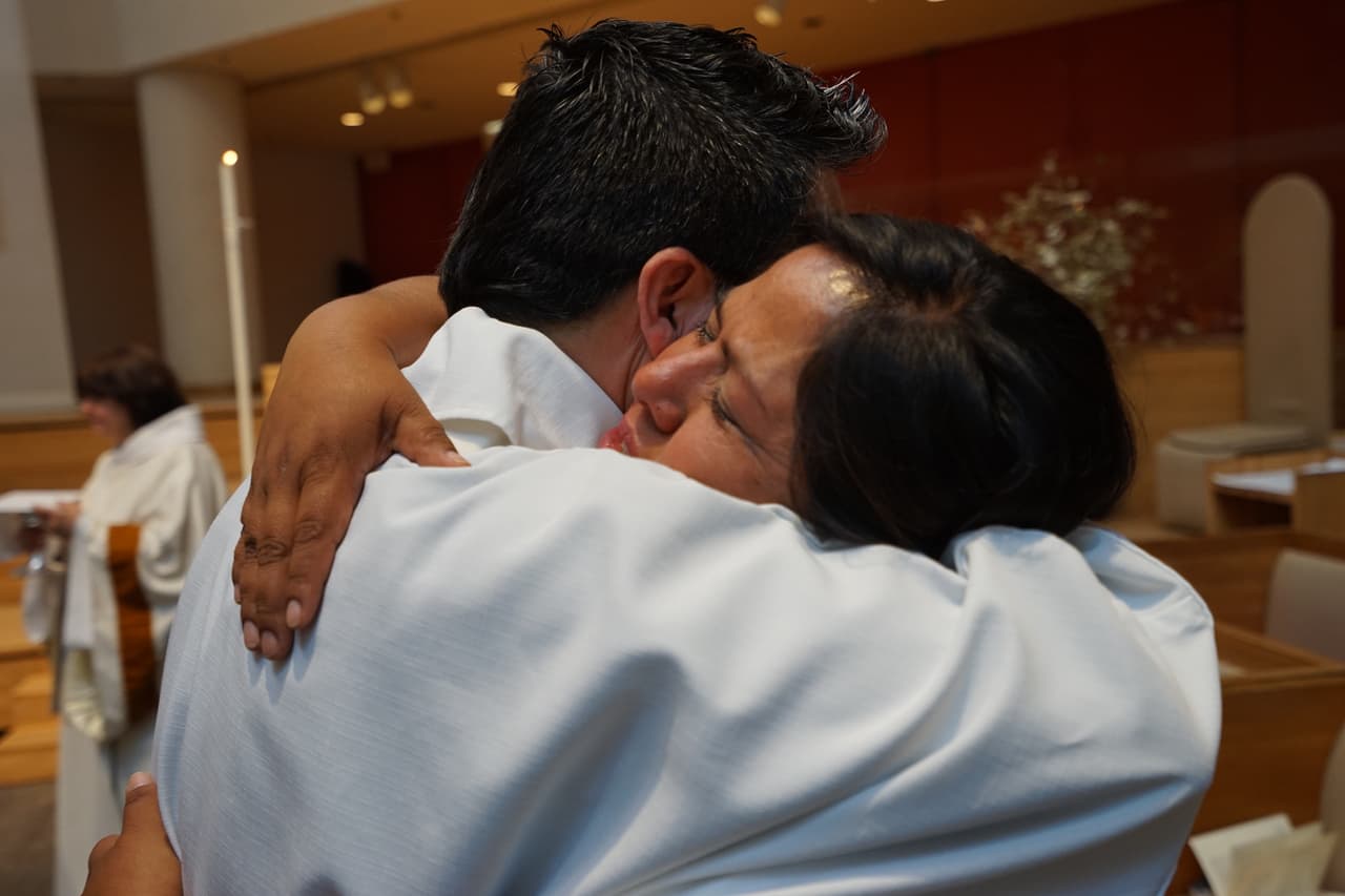 Mirna abraza al padre Juan Carlos Ruíz, un defensor de los derechos de los inmigrantes.