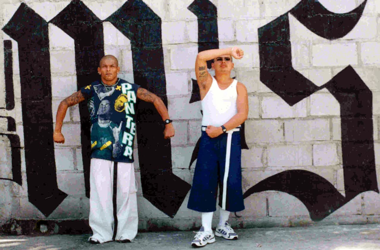 En marzo de 2012, los líderes de la MS13 y sus rivales de Barrio18 acordaron una tregua nacional negociada a través de grupos de la comunidad y la iglesia, y facilitada por el gobierno. El aparente cese al fuego fue seguido por una gran caída en la tasa de homicidios de El Salvador y los pandilleros
<a href="http://www.univision.com/noticias/noticias-de-latinoamerica/maras-suspenden-reclutamiento-de-jovenes-en-el-salvador"> suspendieron el reclutamiento forzado de jóvenes.</a> En Centroamérica las bandas criminales han podido reconstruir sus estructuras organizativas desde el interior de las cárceles, así como expandir su capacidad de llevar a cabo delitos como secuestros, robo de autos, esquemas de extorsión, y otras actividades criminales. En la imagen, dos miembros de la ‘Mara Salvatrucha ‘posan en una calle de Tegucigalpa, Honduras, en 2014.
<br>