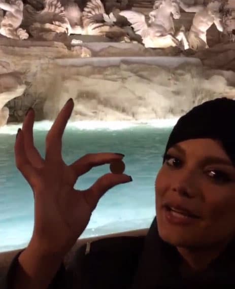 Enseñando a sus fans la moneda que tiraría en la Fuente de Trevi.