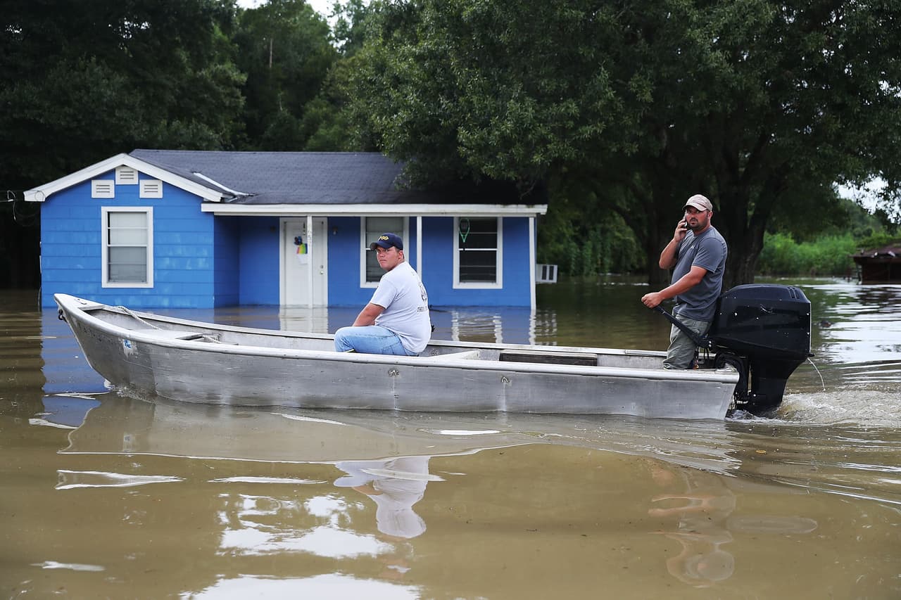 Dos damnificados visitan su vecindario inundado en el sur de Louisiana.