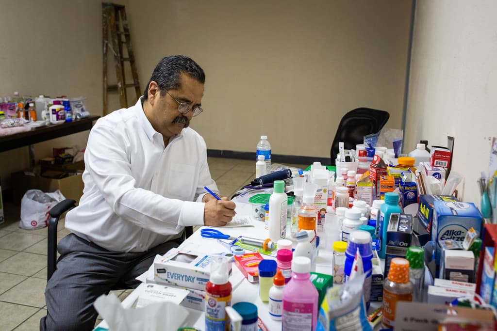 El doctor José Manuel de la Rosa completa una receta en una clínica improvisada en un viejo depósito en El Paso.