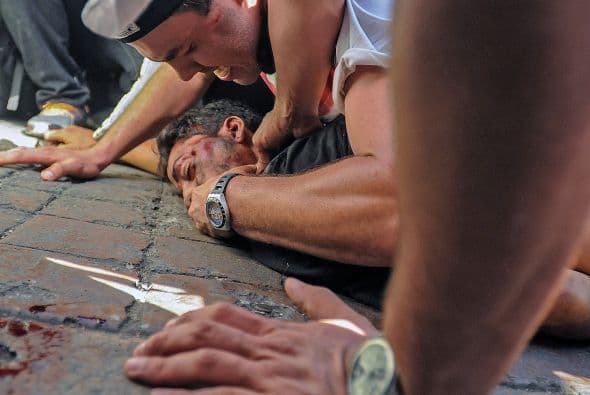 Un hombre revisa los signos vitales de DaCosta. El estudiante yace en el pavimento. Los disparos que recibió le causaron la murte.