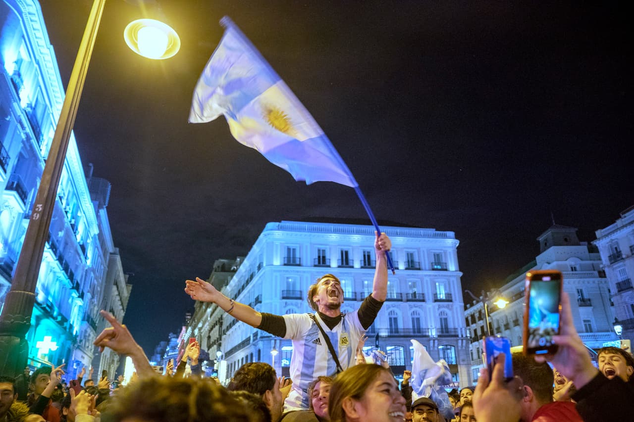 Hinchas argentinos celebran en las calles de Madrid una vez finalizado el partido, después de que Gonzalo Montiel marcara el gol decisivo en la tanda de penales (que terminó con un 4-2 a favor de Argentina) tras el empate 3-3.