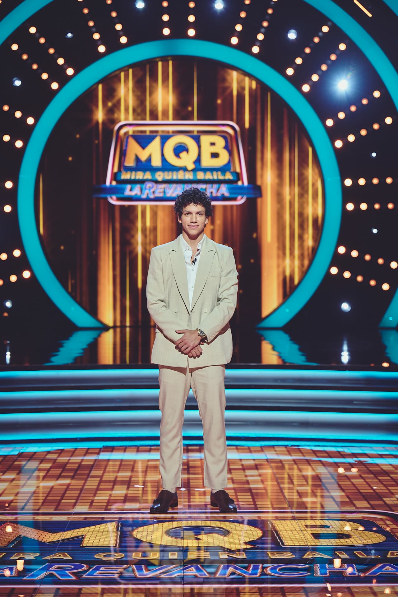 Isaac Hernández lució un elegante traje en tonos neutros, complementado por una camisa blanca sin corbata, proyectando una imagen cómoda y casual con estilo.