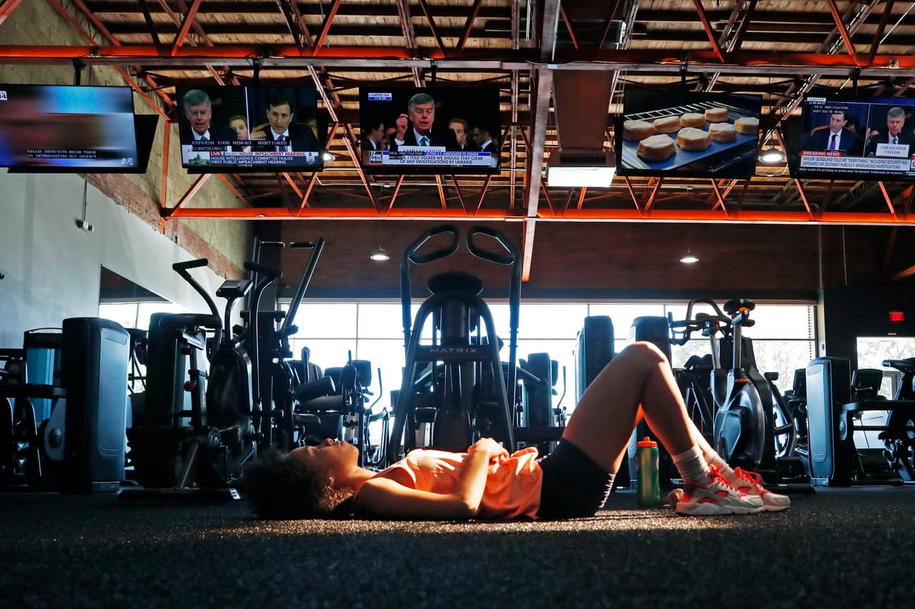 La Constitución establece un drástico, pero ambiguo, parámetro para el juicio político y hasta ahora no existe un consenso de que las acciones de Trump en las que se centra la pesquisa cumplan con la definición de "delitos y faltas graves". En la fotografía Cindy Alvarez, quien mira el procedimiento en el gimnasio al que acostumbra a ir en Jackson, Mississippi.